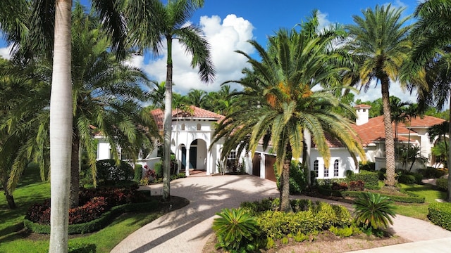 1186 Breakers W Blvd, West Palm Beach, FL 33411 - mediterranean / spanish house featuring decorative driveway, stucco siding, and a garage