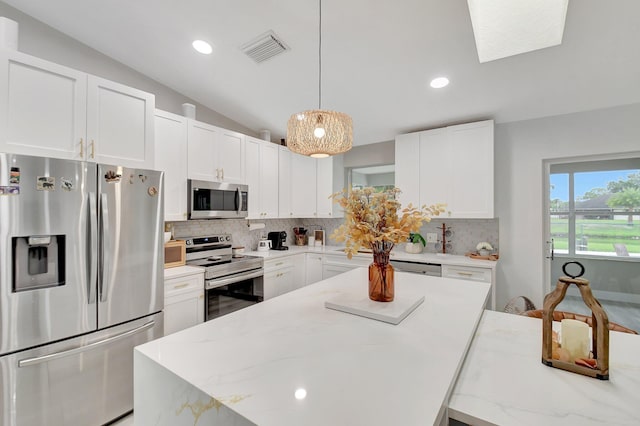 298 Las Palmas St, Royal Palm Beach, FL 33411 - kitchen with stainless steel appliances, backsplash, white cabinets, lofted ceiling, and recessed lighting