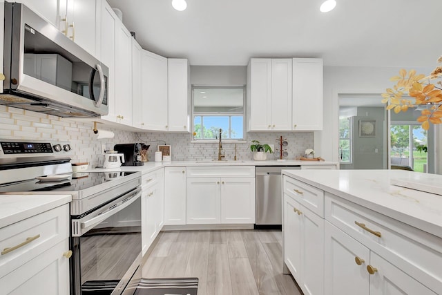 298 Las Palmas St, Royal Palm Beach, FL 33411 - kitchen with stainless steel appliances, a sink, backsplash, white cabinets, and recessed lighting