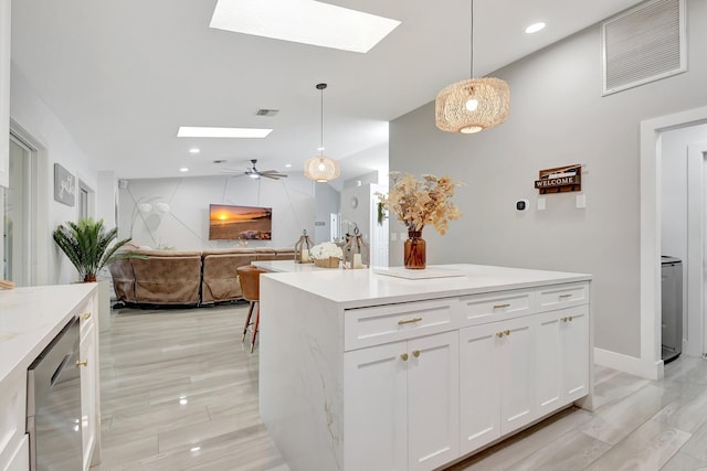 298 Las Palmas St, Royal Palm Beach, FL 33411 - kitchen with a skylight, white cabinets, pendant lighting, ceiling fan, and open floor plan