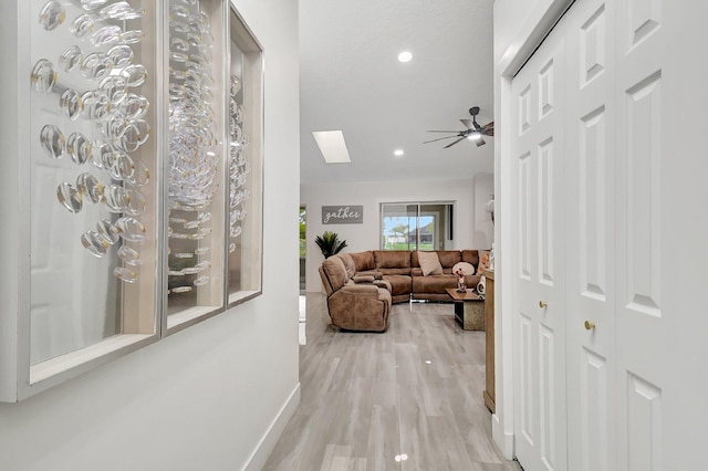 298 Las Palmas St, Royal Palm Beach, FL 33411 - hallway featuring light wood-type flooring, a skylight, baseboards, and recessed lighting