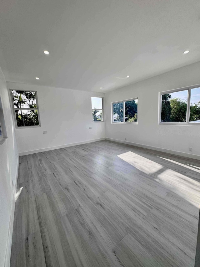 3056 NE 14th Ave, Oakland Park, FL 33334 - unfurnished living room with recessed lighting, plenty of natural light, wood finished floors, and baseboards