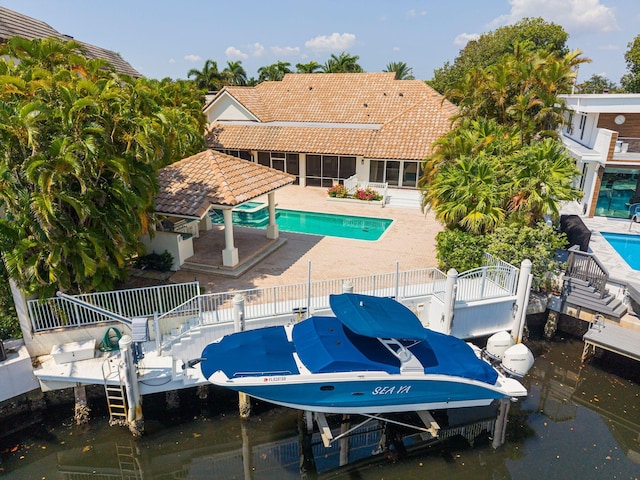 4700 Sanctuary Ln, Boca Raton, FL 33431 - dock featuring boat lift, an outdoor pool, and a patio area