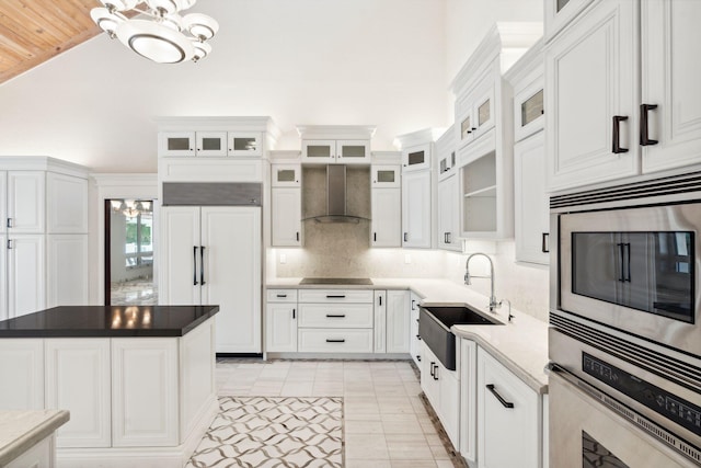 4700 Sanctuary Ln, Boca Raton, FL 33431 - kitchen with wall chimney exhaust hood, built in appliances, a chandelier, white cabinets, and backsplash