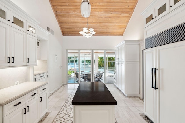 4700 Sanctuary Ln, Boca Raton, FL 33431 - kitchen with paneled fridge, wood ceiling, white cabinets, hanging light fixtures, and high vaulted ceiling