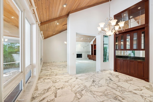 4700 Sanctuary Ln, Boca Raton, FL 33431 - foyer featuring a wooden ceiling with exposed beams, a high end fireplace, marble tiled flooring, a chandelier, and high vaulted ceiling