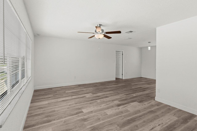 798 SE Atlantus Ave, Port Saint Lucie, FL 34983 - spare room featuring ceiling fan, wood finished floors, baseboards, and a textured ceiling