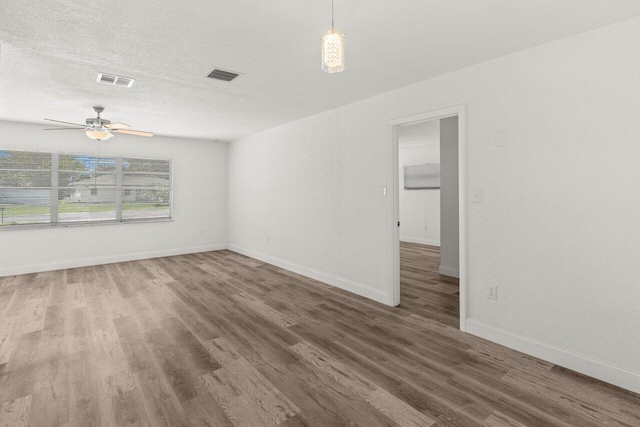 798 SE Atlantus Ave, Port Saint Lucie, FL 34983 - unfurnished room featuring wood finished floors, a ceiling fan, baseboards, and a textured ceiling
