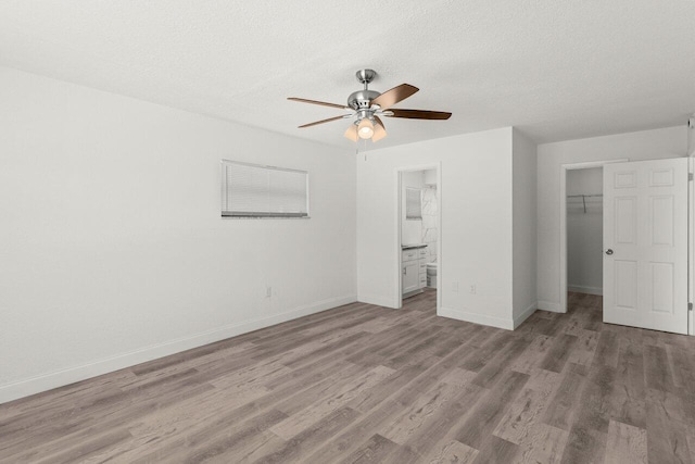 798 SE Atlantus Ave, Port Saint Lucie, FL 34983 - unfurnished bedroom featuring wood finished floors, a closet, baseboards, and a textured ceiling