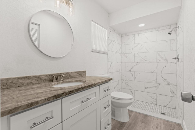 798 SE Atlantus Ave, Port Saint Lucie, FL 34983 - full bath with vanity, a tile shower, toilet, and wood finished floors