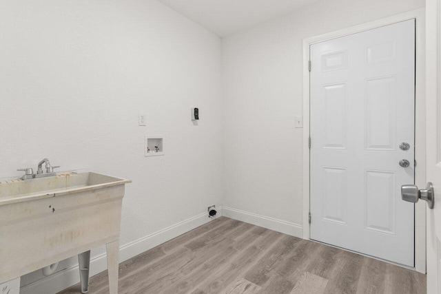798 SE Atlantus Ave, Port Saint Lucie, FL 34983 - laundry area with washer hookup, light wood finished floors, and baseboards