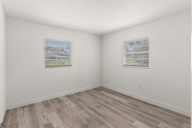 798 SE Atlantus Ave, Port Saint Lucie, FL 34983 - empty room with wood finished floors, baseboards, and a textured ceiling