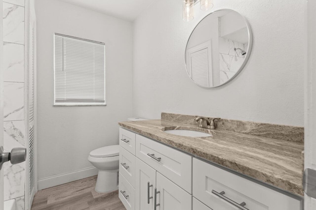 798 SE Atlantus Ave, Port Saint Lucie, FL 34983 - bathroom with vanity, wood finished floors, toilet, baseboards, and a shower