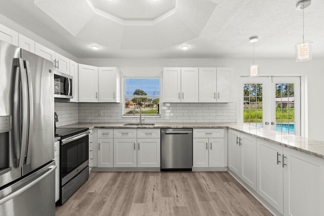 798 SE Atlantus Ave, Port Saint Lucie, FL 34983 - kitchen with stainless steel appliances, a sink, plenty of natural light, light wood-style floors, and a textured ceiling