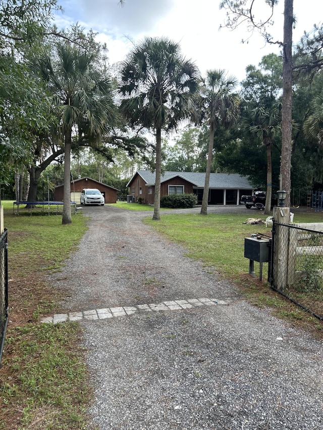 12323 N 188th St N, Jupiter, FL 33478 - view of front of property with driveway, a trampoline, and a detached carport