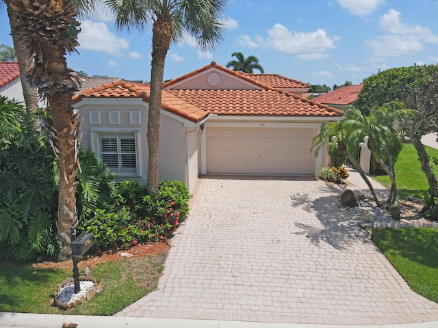 7158 Foxworth Ct, Boynton Beach, FL 33437 - mediterranean / spanish-style house with an attached garage, stucco siding, a tiled roof, and decorative driveway