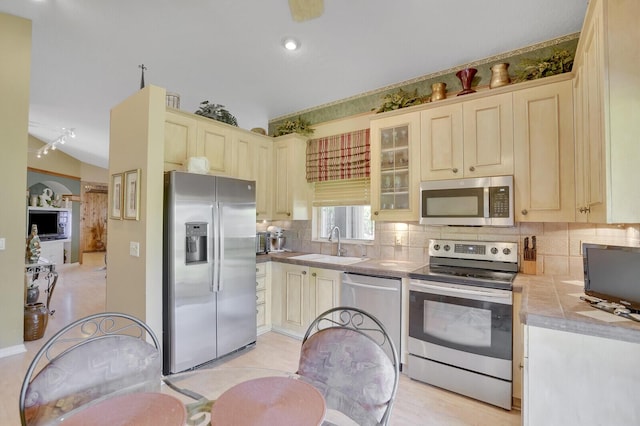 7158 Foxworth Ct, Boynton Beach, FL 33437 - kitchen featuring appliances with stainless steel finishes, a sink, tasteful backsplash, glass insert cabinets, and tile counters
