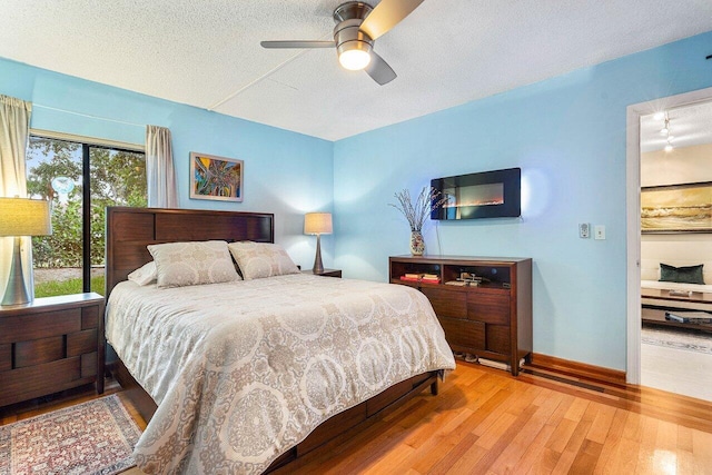 5200 E Club Cir Unit 106, Boca Raton, FL 33487 - bedroom featuring wood finished floors, a textured ceiling, ceiling fan, and baseboards