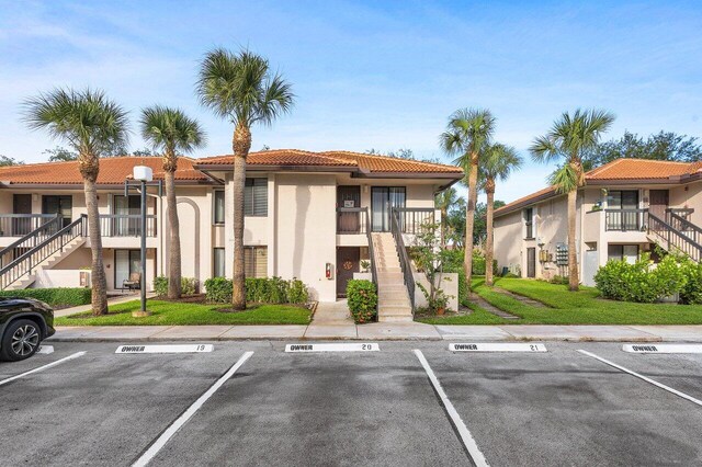 5200 E Club Cir Unit 106, Boca Raton, FL 33487 - view of building exterior with stairs and uncovered parking