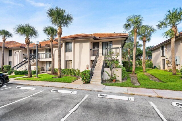 5200 E Club Cir Unit 106, Boca Raton, FL 33487 - view of building exterior featuring stairway and uncovered parking