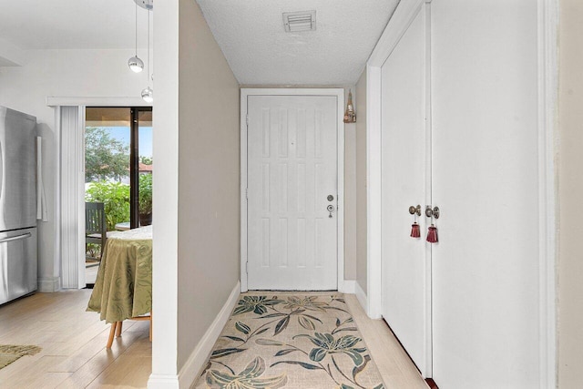 5200 E Club Cir Unit 106, Boca Raton, FL 33487 - doorway featuring light wood-type flooring, a textured ceiling, and baseboards