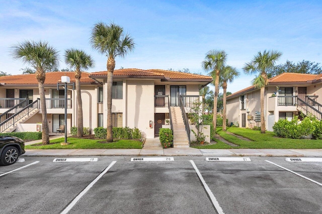 5200 E Club Cir Unit 106, Boca Raton, FL 33487 - view of building exterior featuring stairs and uncovered parking