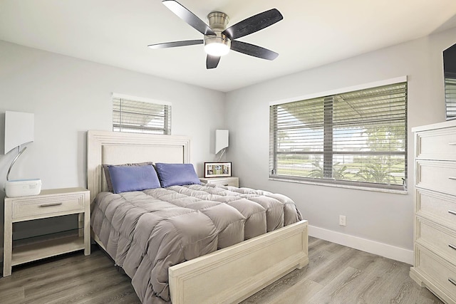 2388 SW Congress Blvd, Boynton Beach, FL 33426 - bedroom featuring multiple windows, baseboards, light wood-style floors, and a ceiling fan