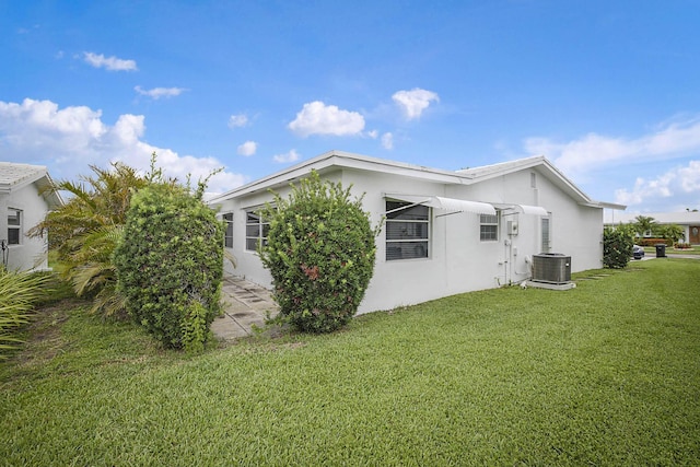 2388 SW Congress Blvd, Boynton Beach, FL 33426 - view of side of home featuring stucco siding, central AC unit, and a lawn