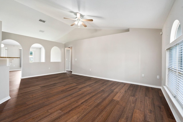 1552 SW Neponset Rd, Port Saint Lucie, FL 34953 - empty room featuring a ceiling fan, dark wood-style floors, vaulted ceiling, healthy amount of natural light, and baseboards