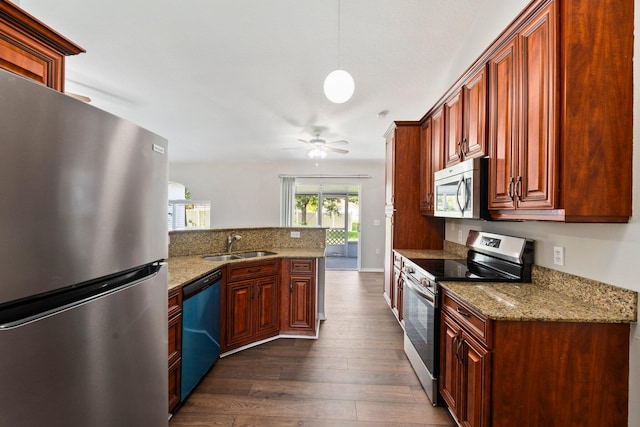 1552 SW Neponset Rd, Port Saint Lucie, FL 34953 - kitchen with appliances with stainless steel finishes, dark wood finished floors, a sink, ceiling fan, and light stone countertops