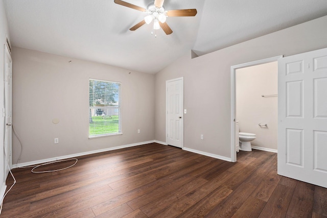 1552 SW Neponset Rd, Port Saint Lucie, FL 34953 - unfurnished bedroom with dark wood-type flooring, vaulted ceiling, ensuite bathroom, baseboards, and ceiling fan