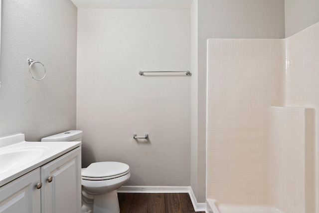 1552 SW Neponset Rd, Port Saint Lucie, FL 34953 - full bathroom featuring wood finished floors, tiled shower, toilet, vanity, and baseboards
