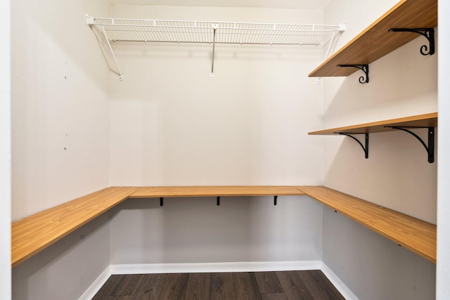 1552 SW Neponset Rd, Port Saint Lucie, FL 34953 - walk in closet featuring built in desk and dark wood finished floors