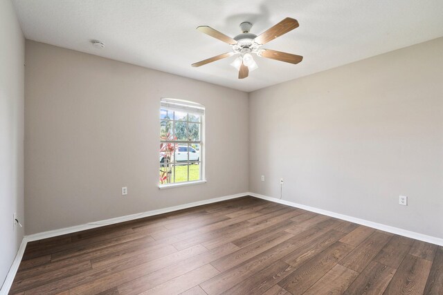 1552 SW Neponset Rd, Port Saint Lucie, FL 34953 - empty room with dark wood-style flooring, ceiling fan, a smoke detector, and baseboards