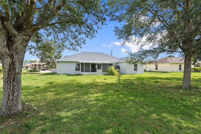 1552 SW Neponset Rd, Port Saint Lucie, FL 34953 - back of house featuring a sunroom, a lawn, and stucco siding