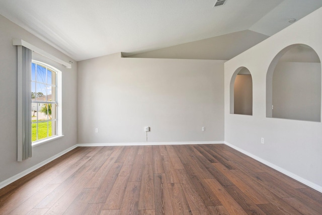 1552 SW Neponset Rd, Port Saint Lucie, FL 34953 - empty room with wood finished floors, vaulted ceiling, and baseboards