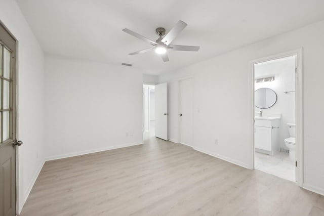 1803 NE 29th Pl, Ocala, FL 34479 - unfurnished bedroom with light wood-style floors, ensuite bathroom, baseboards, and a ceiling fan