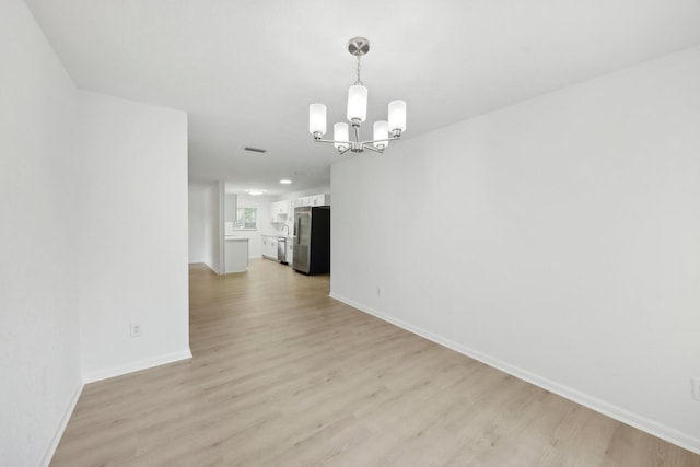 1803 NE 29th Pl, Ocala, FL 34479 - unfurnished dining area featuring a chandelier, light wood-type flooring, and baseboards