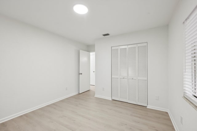 1803 NE 29th Pl, Ocala, FL 34479 - unfurnished bedroom with light wood-style flooring, a closet, and baseboards