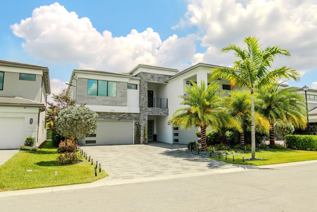 8305 Fishhawk Falls Ct, Boca Raton, FL 33496 - contemporary house with stone siding, a balcony, a garage, decorative driveway, and a front yard