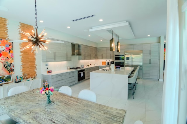 8305 Fishhawk Falls Ct, Boca Raton, FL 33496 - kitchen with modern cabinets, wall chimney range hood, a chandelier, appliances with stainless steel finishes, and hanging light fixtures