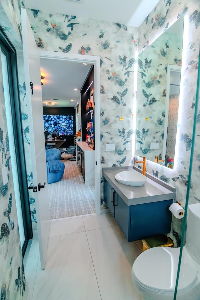 8305 Fishhawk Falls Ct, Boca Raton, FL 33496 - bathroom with wallpapered walls, toilet, vanity, and marble look tiles