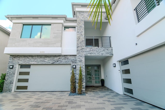 8305 Fishhawk Falls Ct, Boca Raton, FL 33496 - contemporary house featuring french doors, an attached garage, stucco siding, a balcony, and driveway