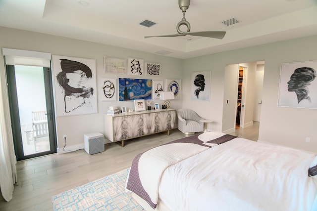 8305 Fishhawk Falls Ct, Boca Raton, FL 33496 - bedroom featuring light wood-style flooring, a tray ceiling, baseboards, a walk in closet, and ceiling fan