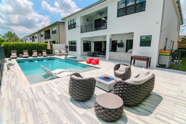 8305 Fishhawk Falls Ct, Boca Raton, FL 33496 - view of swimming pool with ceiling fan, a patio, a pool with connected hot tub, and an outdoor living space with a fire pit