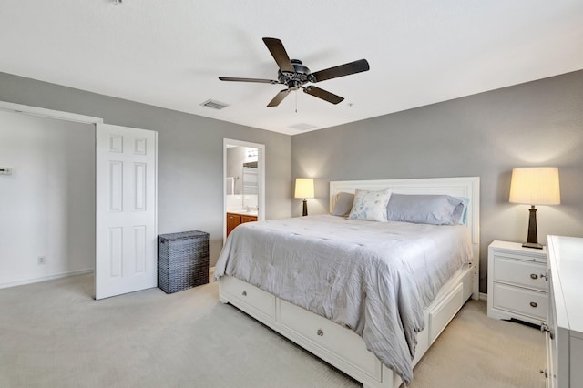5285 SE Jennings Ln, Stuart, FL 34997 - bedroom with light colored carpet, ceiling fan, ensuite bathroom, and baseboards