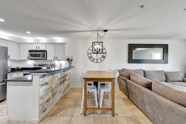 5285 SE Jennings Ln, Stuart, FL 34997 - kitchen with appliances with stainless steel finishes, a peninsula, dark countertops, open floor plan, and pendant lighting