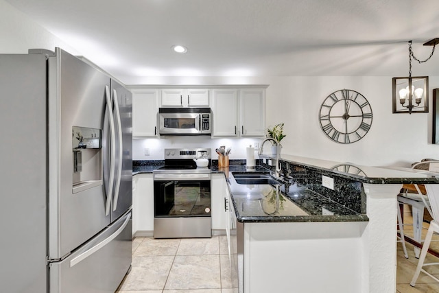5285 SE Jennings Ln, Stuart, FL 34997 - kitchen with appliances with stainless steel finishes, a sink, a peninsula, a kitchen breakfast bar, and dark stone countertops