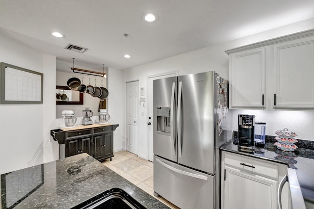 5285 SE Jennings Ln, Stuart, FL 34997 - kitchen with stainless steel fridge with ice dispenser, dark stone counters, recessed lighting, and light tile patterned floors