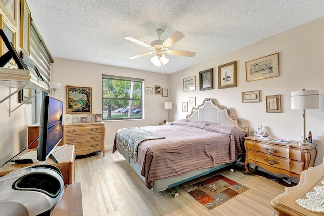 4101 Coral Tree Cir Unit 116, Coconut Creek, FL 33073 - bedroom with light wood-style flooring, a textured ceiling, and a ceiling fan